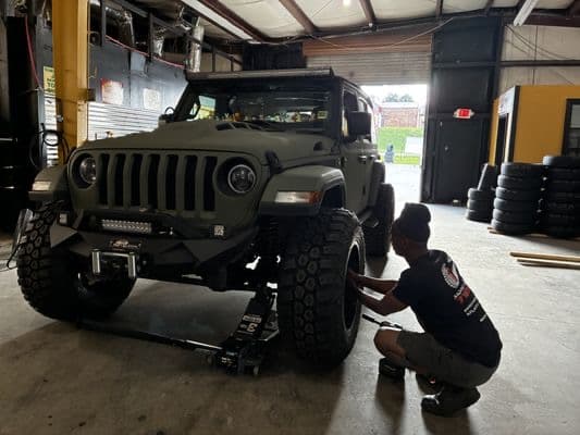 Employee changing a tire at More Miles Tires